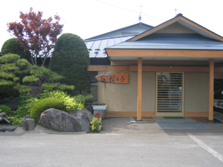 入り口左側に植栽がある稲垣温泉ホテル花月亭の外観を写した写真