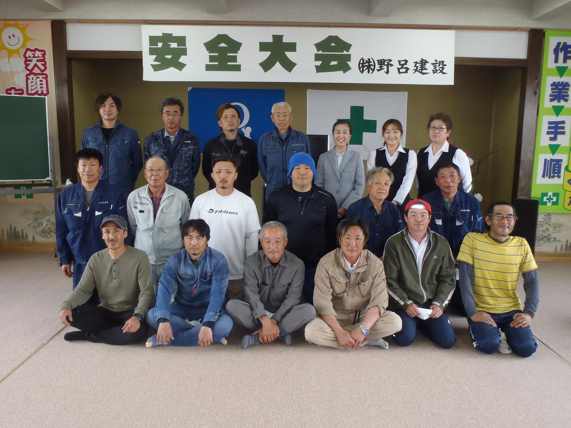 安全大会と書かれた横断幕を背に3列に並ぶ野呂建設社員19名の写真