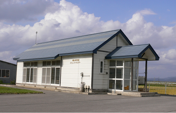 白い外壁の平屋建ての建物で青い三角屋根の権現・深沢地区コミュニティセンターの外観写真