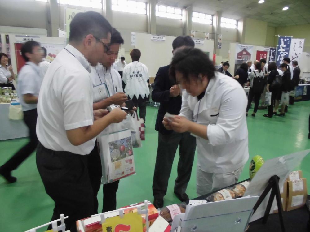 会場内で県外のお客様と店舗の方が名刺交換をしている様子の写真