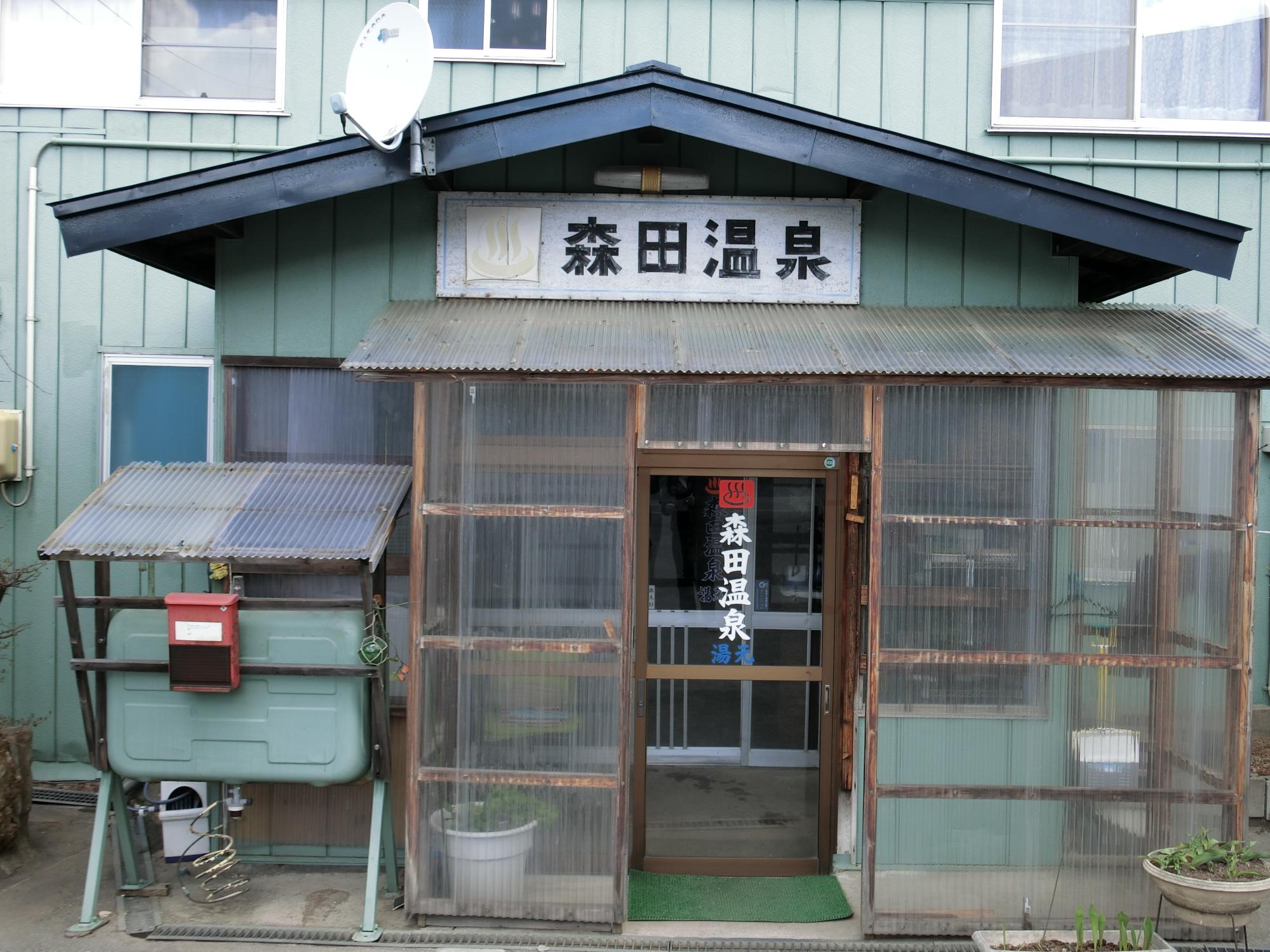 玄関上に「森田温泉」の看板が掲げられた森田温泉玄関前の外観写真