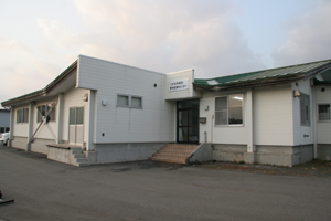 緑色の屋根に白色の外壁で玄関入口に段差がある森田学校給食センターの外観写真