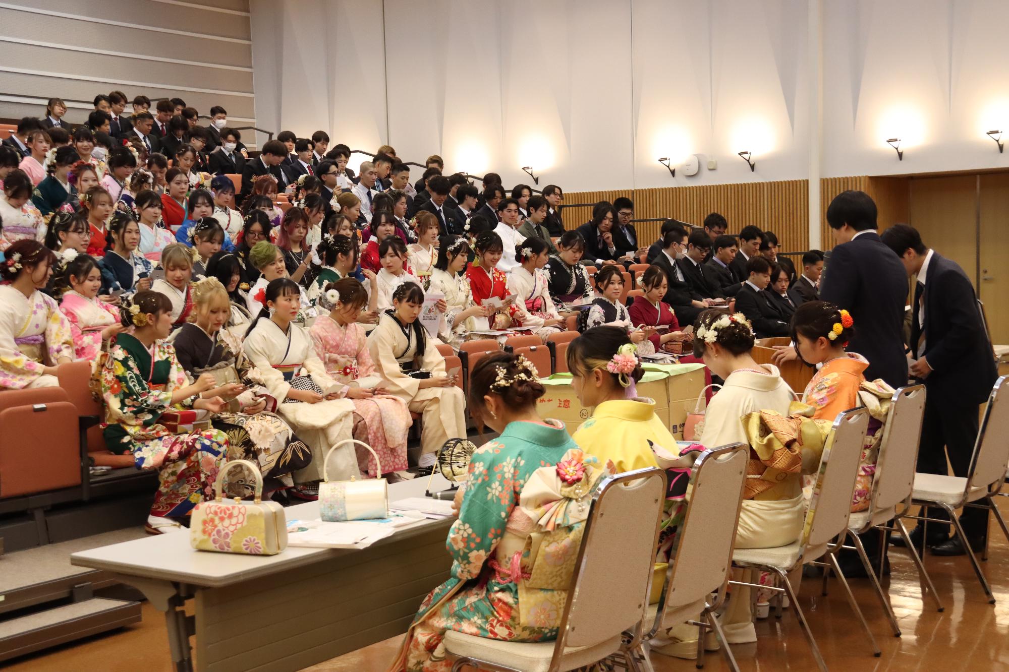 ビンゴゲームで番号を読み上げる実行委員と参加者の写真