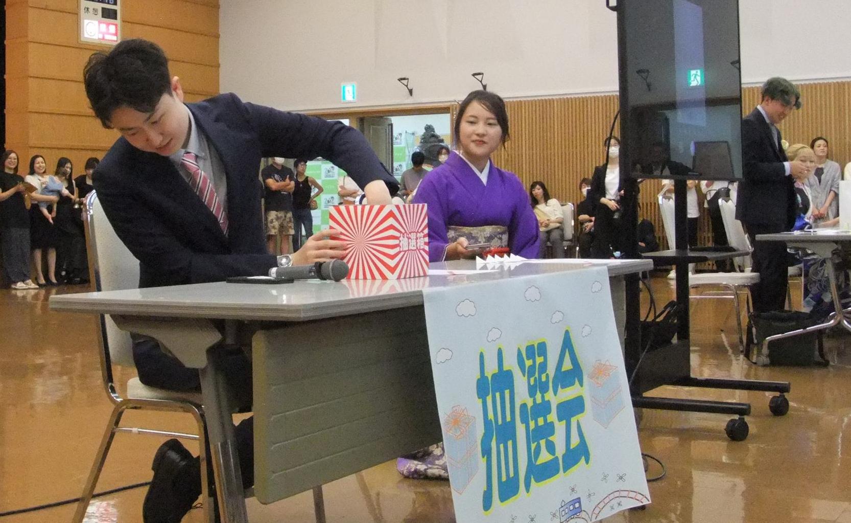 抽選箱から番号を引く実行委員の写真