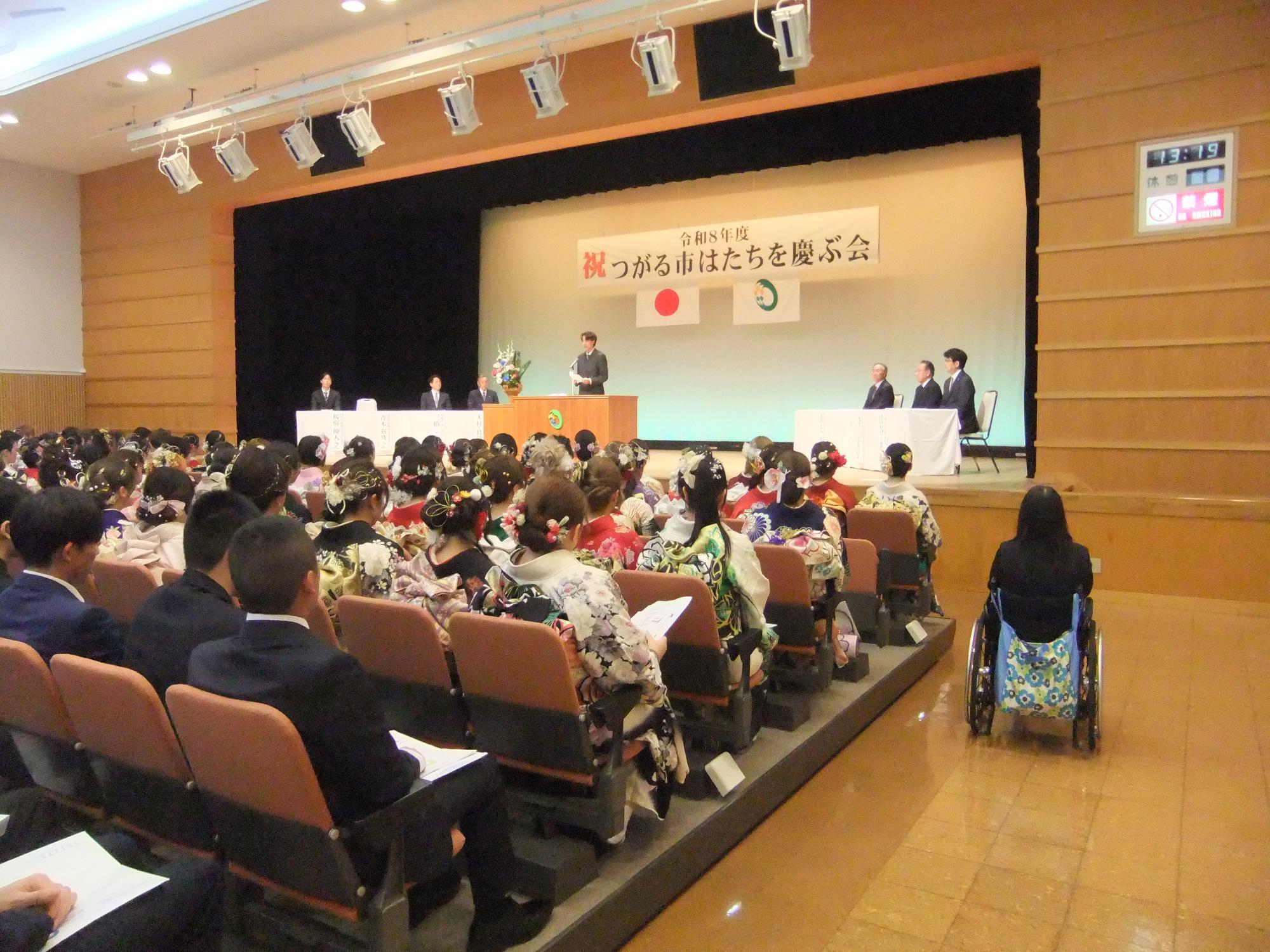 色鮮やかな髪飾りや振袖を着用した参加者が会場で並んでいる写真