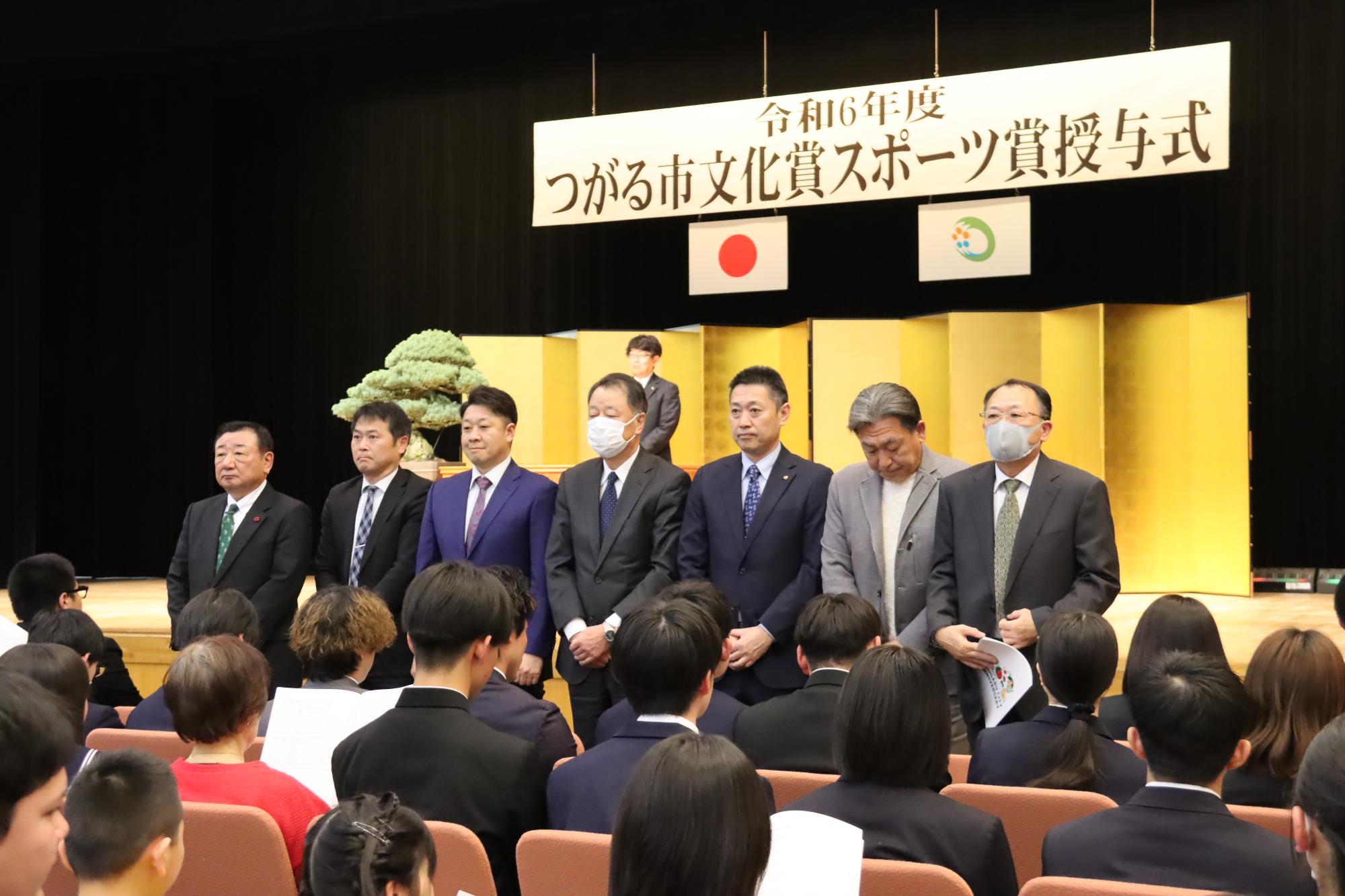 名前を呼ばれた受賞者が客席を向いて起立している様子
