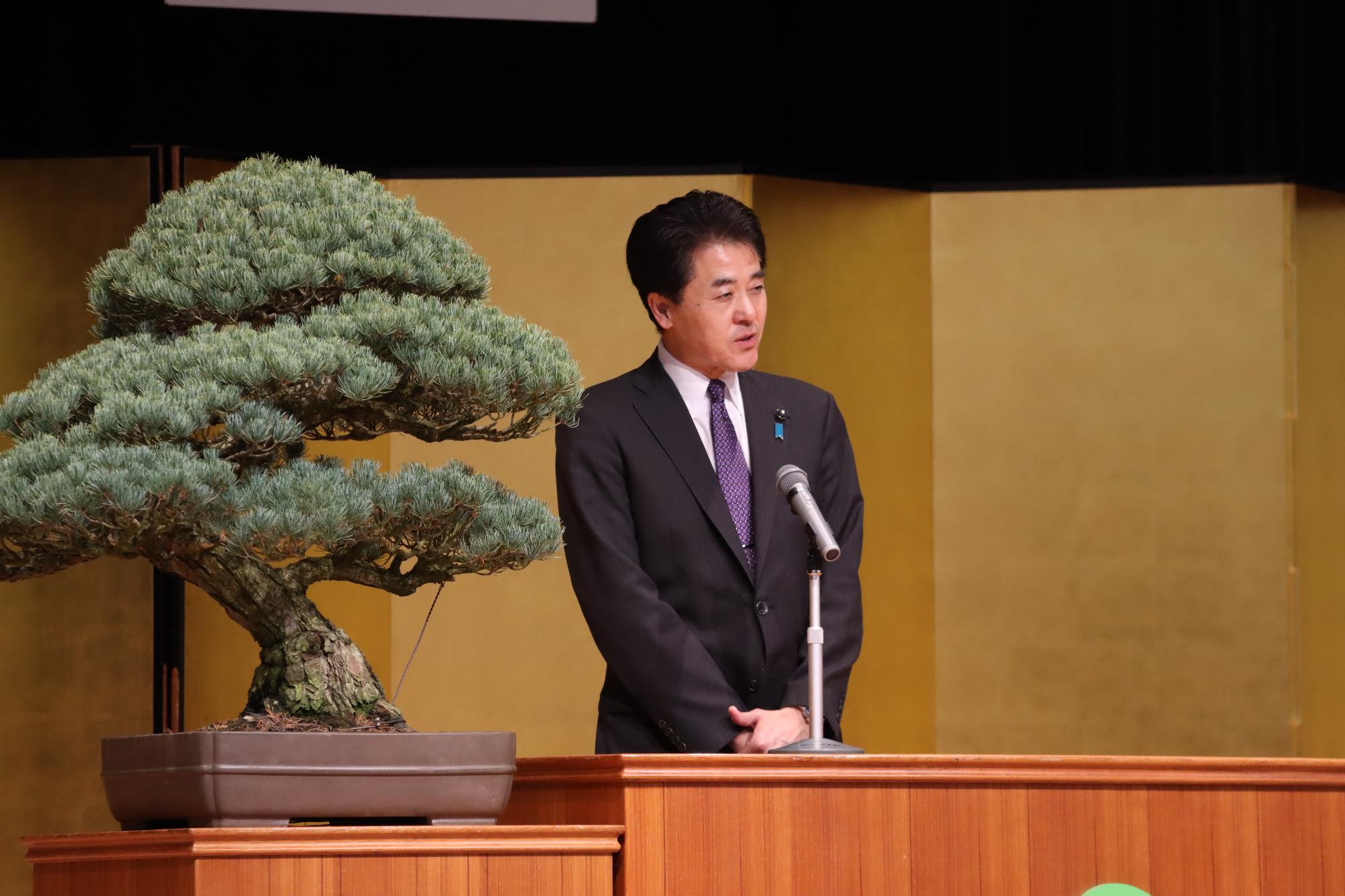 県議会議員が祝辞を読んでいる様子