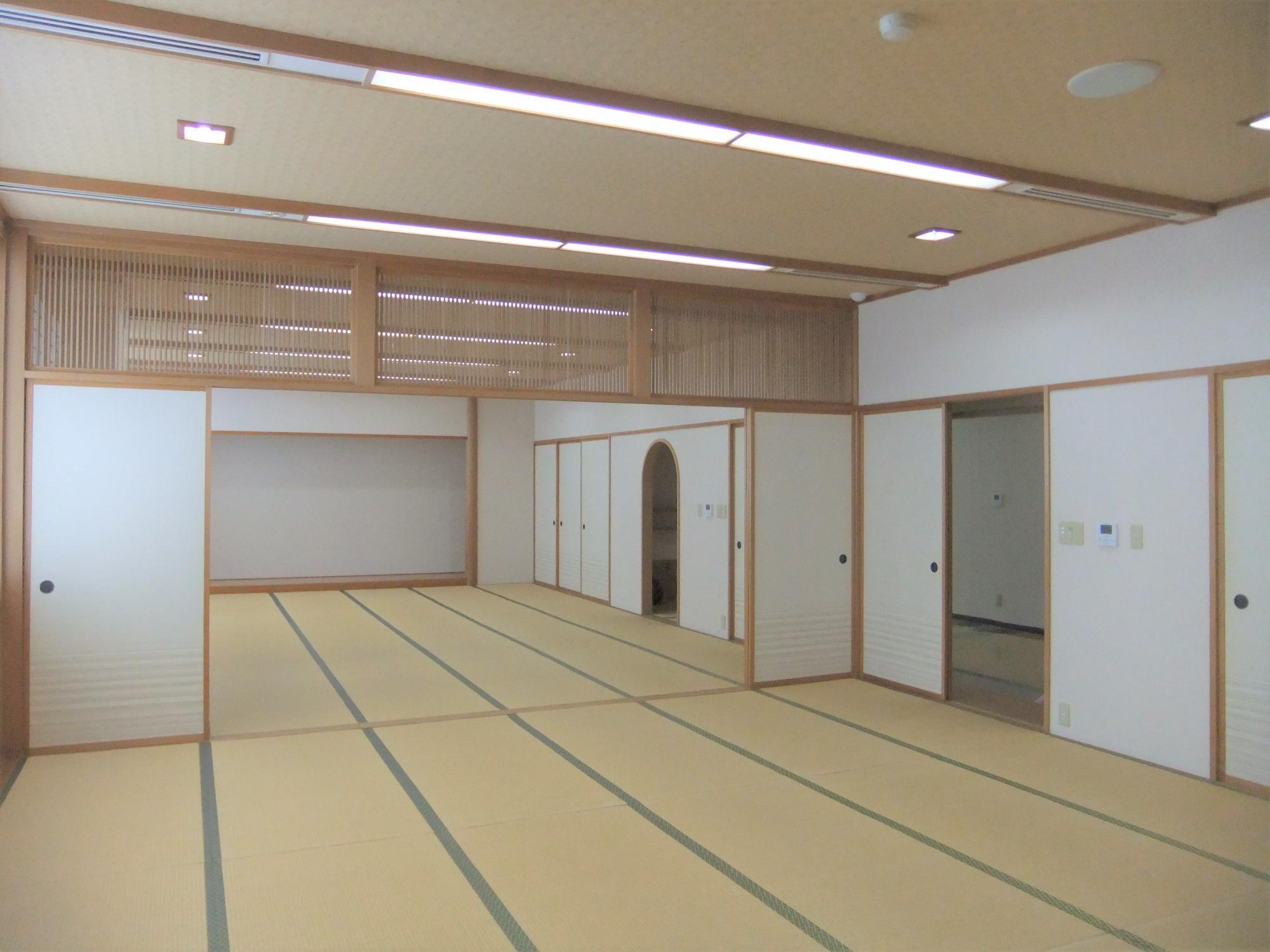 畳が一面に敷かれ水屋も設置されている和室内の写真